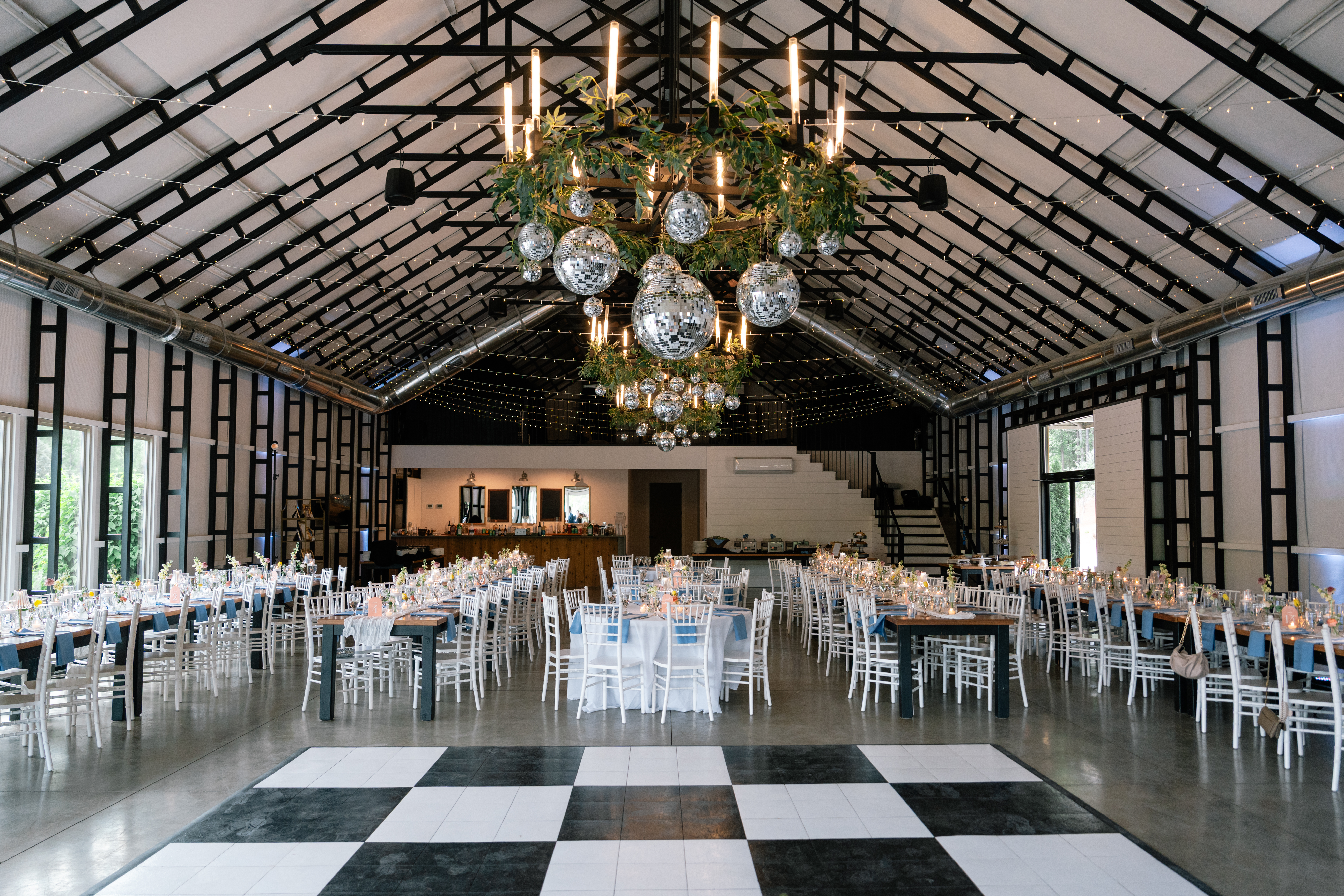 Hydrangea Hall interior — checkered dance floor and disco ball chandeliers