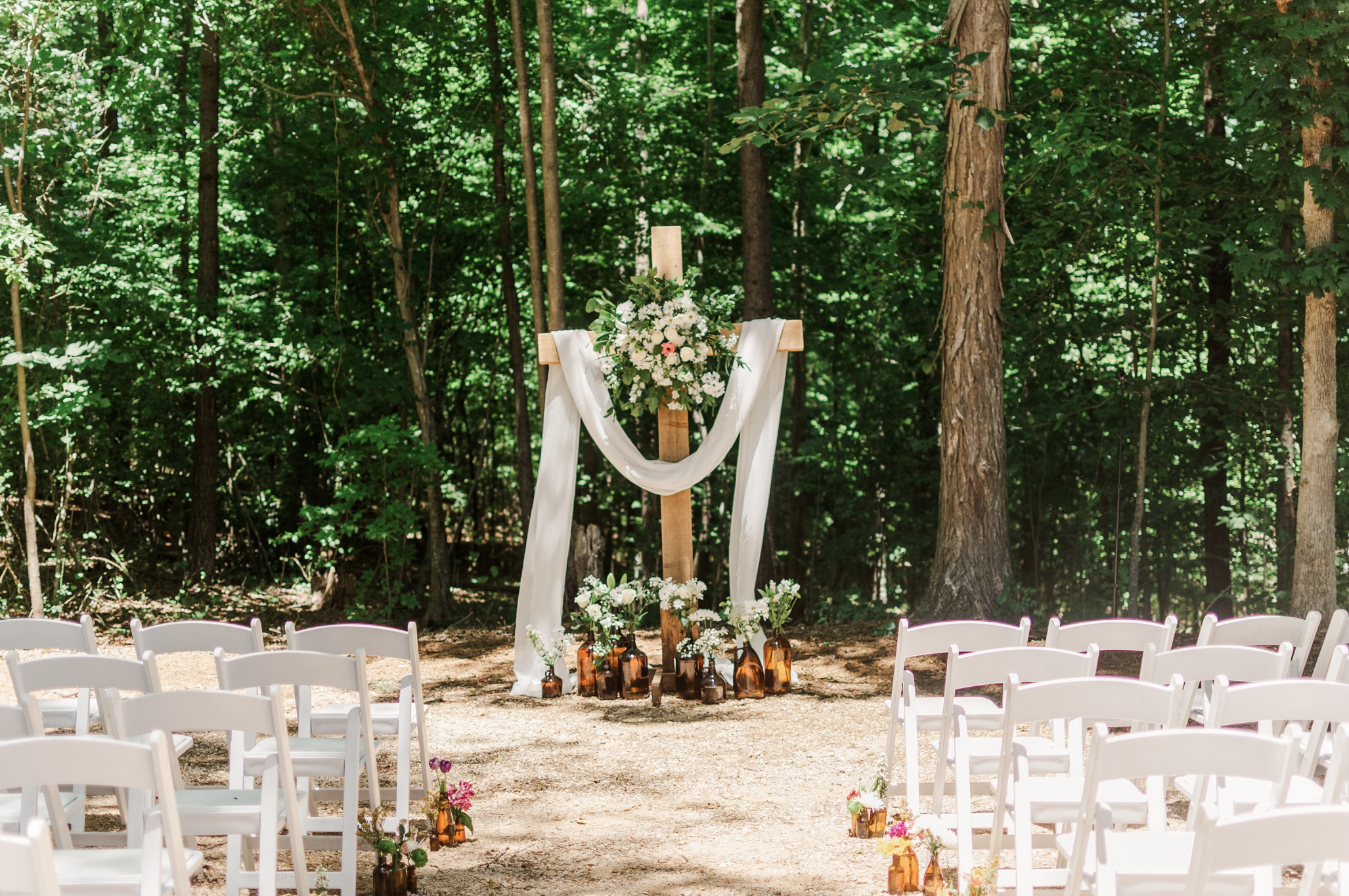 The Woodlands — bride and groom walking through trees toward pond